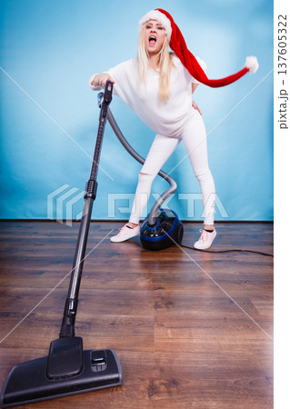 Funny girl in santa helper hat with vacuum cleaner 137605322