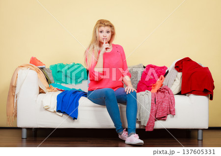 Woman does not know what to wear sitting on couch Woman does not know what to wear sitting on couch 137605331