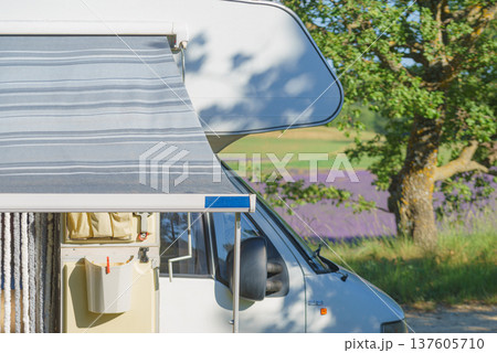 Camper with an awning extended, providing shade for outdoor relaxation Camper with an awning extended, providing shade for outdoor relaxation 137605710