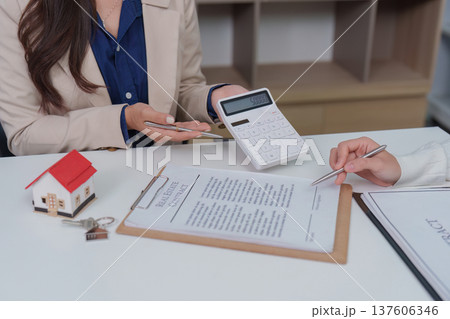 Real Estate Consultation. Agent using calculator to discuss property finances. 137606346