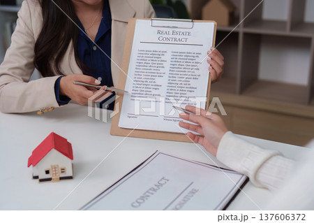 Real Estate. Client reviewing real estate contract with agent in office. Real Estate. Client reviewing real estate contract with agent in office. 137606372