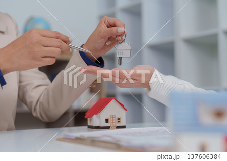 Property Handover. Agent giving keys to client during real estate transaction. 137606384