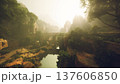 Sunlit stone bridge over river valley, golden rays pierce morning mist, ancient mosscovered masonry blends with lush trees, distant rocky cliffs rise 137606850