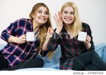 Female friends gossiping together Female friends gossiping together 137607103