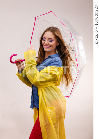 Woman wearing waterproof coat under umbrella 137607227