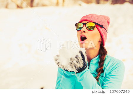 Girl holding snow in park 137607249