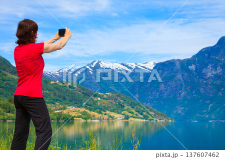 Tourist taking photo at norwegian fjord 137607462