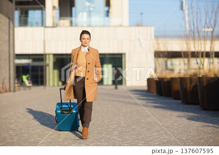 Confident Businesswoman with Suitcase at Train Station 137607595
