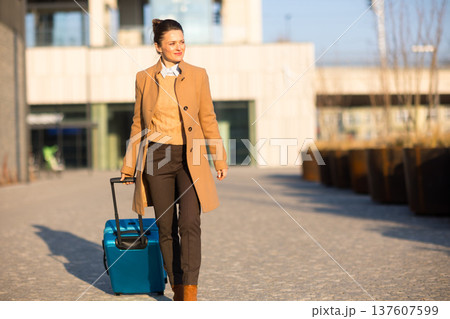 Confident Businesswoman with Suitcase at Railway Station 137607599