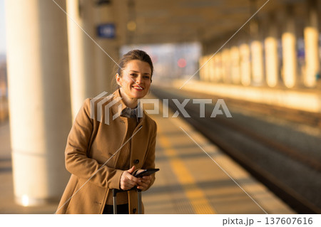 Confident Businesswoman with Suitcase at Railway Station 137607616