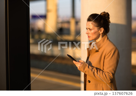 Thoughtful Woman Waiting at Modern Transportation Hub Thoughtful Woman Waiting at Modern Transportation Hub 137607626