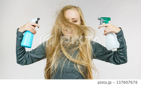 Female messy long hair holds spray bottle Female messy long hair holds spray bottle 137607678