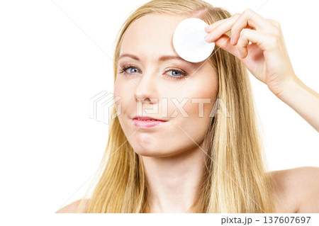 Woman cleaning her face skin with cotton pad 137607697