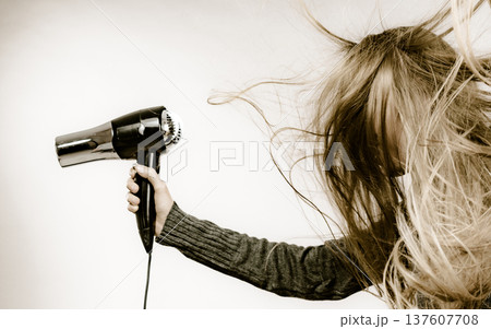 Girl styling her long hair Girl styling her long hair 137607708