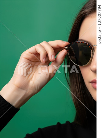 Close up of an anonymous hand adjusting stylish round sunglasses on a head Close up of an anonymous hand adjusting stylish round sunglasses on a head 137607794