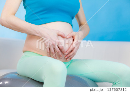 Pregnant woman making heart shape on belly with hands 137607812