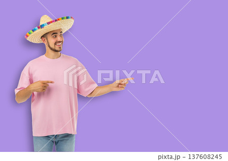 Cinco de Mayo, Young man in sombrero points with a smile, celebrating Cinco de Mayo, Young man in sombrero points with a smile, celebrating 137608245