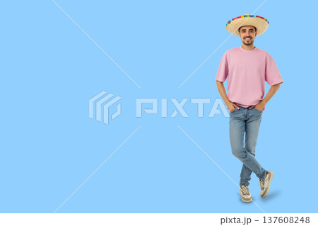 Cinco de Mayo, Young man wears a sombrero and stands with a smile Cinco de Mayo, Young man wears a sombrero and stands with a smile 137608248