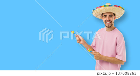 Cinco de Mayo, Young man smiles with maracas and a sombrero 137608263