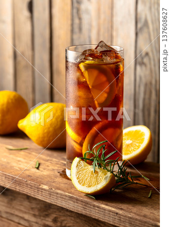 Iced tea or alcoholic cocktail with ice, rosemary and lemon slices on a old wooden table. Iced tea or alcoholic cocktail with ice, rosemary and lemon slices on a old wooden table. 137608627