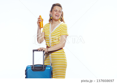 Vacation Ready Woman with Blue Luggage and Sunscreen Spray Vacation Ready Woman with Blue Luggage and Sunscreen Spray 137608697