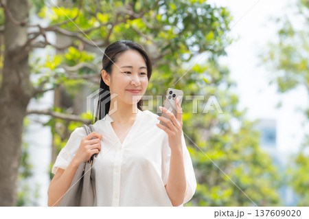 女性 カジュアル 初夏 歩く スマホ 女性 カジュアル 初夏 歩く スマホ 137609020