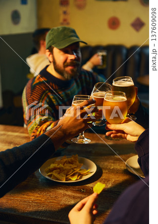 Beer toast with friends in pub enjoying social drinking and relaxed nightlife atmosphere 137609098
