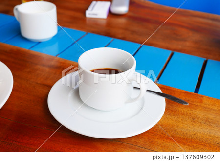 Cup of coffee on table in cafe in bright daytime. White cup witn coffee  137609302