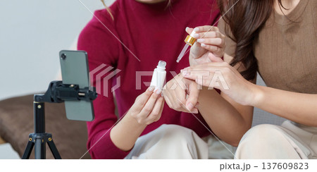 Skincare Routine. Friends demonstrating product application in a beauty tutorial. 137609823