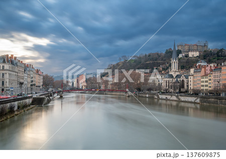 Lyon, france. December 29, 2023. Lyon cityscape showing the saone river, saint georges church, and historic buildings under a cloudy sky during blue hour 137609875