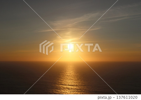 Golden Sunset Over the Atlantic Ocean with Sunstar Flare and Calm Water 137611020