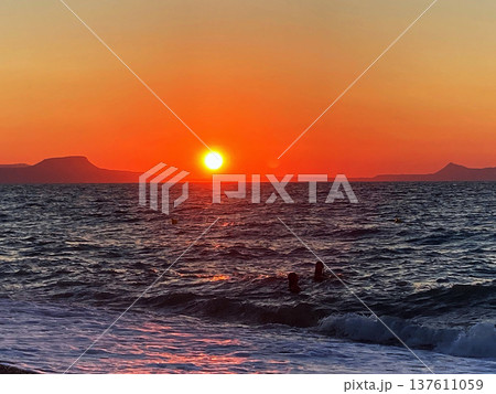 summer sunset on the sea coast in Creta, Greece, at 02 August 2023. Beautiful sunset by the sea in a beach on Kreta. Fantastic sunset on the Mediterranean Crete 137611059