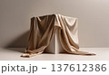 Elegant silk fabric draped over geometric cube creating minimal sculptural composition, soft textile folds forming luxury abstract still life design 137612386
