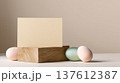 Minimal Easter composition with pastel eggs beside blank card on wooden block, clean spring mockup scene designed for greeting message or seasonal branding 137612387