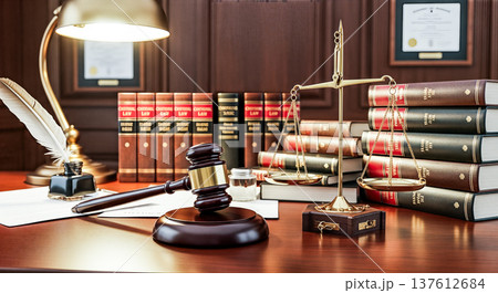 Wooden judge gavel golden scales of justice near stack of law books on lawyer desk inside courtroom representing legal system jurisprudence attorney practice 137612684