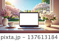 Remote working, spring. laptop with blank screen sits on windowsill surrounded by blooming flowers and cup of coffee, creating serene workspace 137613184