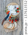 Sliced ciabatta bread, cheese, tomatoes and spices lying on wooden table 137613552