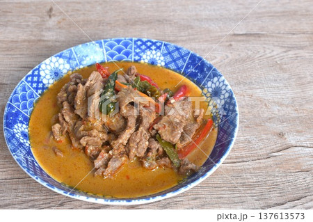 spicy boiled slice beef meat with lemon leaf and eggplant in coconut milk red curry soup on plate 137613573