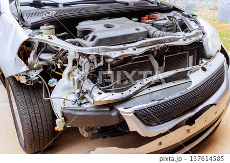 Car with missing front parts being worked on in automobile garage 137614585