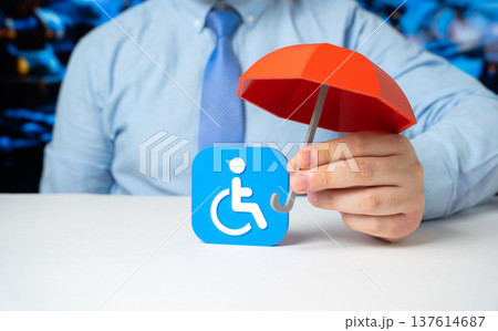 Businessman holds a figurine of a disabled person with a red umbrella. Insurance, safety, inclusion, and financial or social protection. Support for people with disabilities. Businessman holds a figurine of a disabled person with a red umbrella. Insurance, safety, inclusion, and financial or social protection. Support for people with disabilities. 137614687