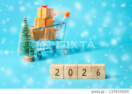 Gifts for family and friends. Celebration season. Wooden blocks with the word 2026, Christmas tree and boxes in a supermarket trolley. Merry Christmas bustle and happy new year 2026 Gifts for family and friends. Celebration season. Wooden blocks with the word 2026, Christmas tree and boxes in a supermarket trolley. Merry Christmas bustle and happy new year 2026 137615020