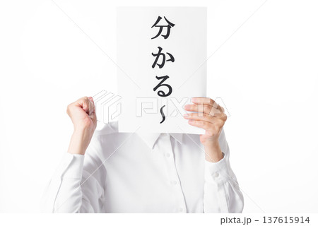 分かるーと書かれた紙を持ちこぶしを握る白いシャツを着た人物 137615914