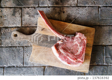 Raw tomahawk steak on cutting board Raw tomahawk steak on cutting board 137616392