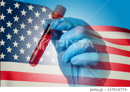 Crophy analysis of a human in a test tube in a doctor's hand against the background of the US flag 137616774