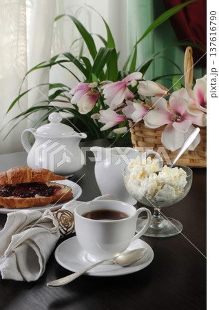 Breakfast tea with croissant, jam and cottage cheese on table 137616790
