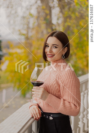 Beautiful young girl with a glass of red wine on a 137616887