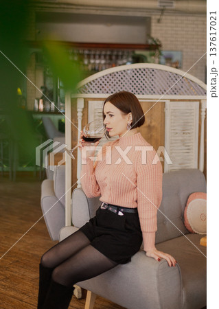 Beautiful young girl sitting at a table in a 137617021