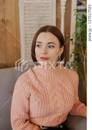 Beautiful young girl sitting at a table in a Beautiful young girl sitting at a table in a 137617083