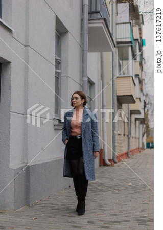 Beautiful young girl walking along an old street Beautiful young girl walking along an old street 137617219