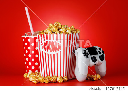 Popcorn, cola and gamepad on red background 137617345